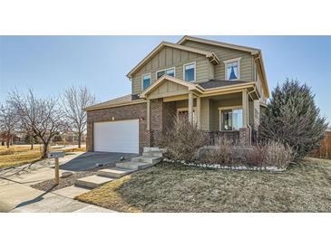 Charming two-story home featuring a brick and siding exterior, attached garage, and inviting front porch at 1960 E 166Th Dr, Thornton, CO 80602