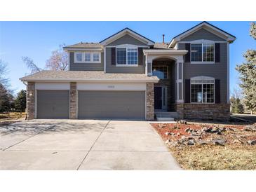 Two-story house with gray siding, stone accents, and a two-car garage at 11729 Elmer Linn Dr, Longmont, CO 80504