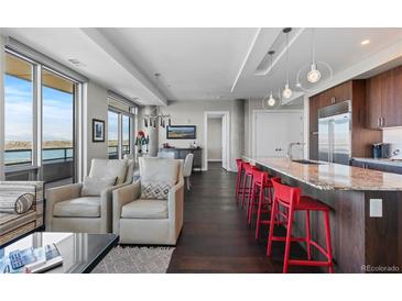 Contemporary living room boasts stylish seating, modern lighting, and an open layout with beautiful hardwood floors at 4200 W 17Th Ave # 912, Denver, CO 80204