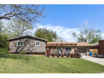 Charming home featuring a well-manicured lawn, mature trees and a welcoming front entrance with a pergola and flower boxes at 760 Deframe St, Golden, CO 80401