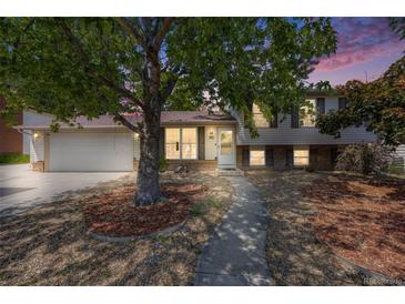 Charming home with a well-maintained lawn and mature trees creating a welcoming curb appeal at 359 S 25Th Ave, Brighton, CO 80601