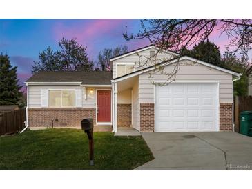 Charming home featuring a brick facade, a red front door, and an attached garage at 17753 E Nassau Pl, Aurora, CO 80013