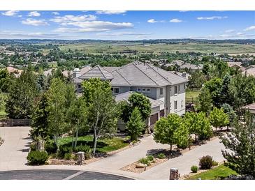 Beautiful two-story home boasts a tiled roof and gorgeous landscaping, set against a backdrop of rolling hills at 5665 Vistancia Ct, Parker, CO 80134