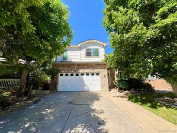 Charming two-story home with stone accents, well-manicured landscaping, and an attached two-car garage at 9466 Morning Glory Ln, Highlands Ranch, CO 80130