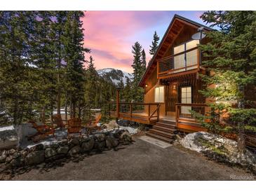 Inviting cabin-style home with a cozy deck, surrounded by lush trees and a mountain view at 563 Brook Dr, Idaho Springs, CO 80452