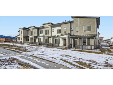 Modern townhouses with light gray siding and stone accents at 14586 W 91St Ave # B, Arvada, CO 80005