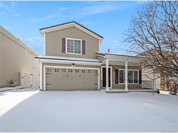 Two-story house with a snow-covered front yard and attached garage at 18986 E 51St Pl, Denver, CO 80249