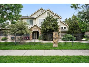 Charming home featuring a stone archway entrance, well-maintained landscaping, and black rod iron fencing at 10010 E Gunnison Pl # 707, Aurora, CO 80247