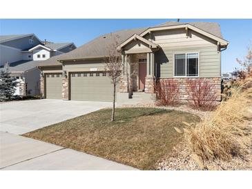 Charming home featuring stone accents, three-car garage and a welcoming entrance at 338 Sage Grouse Cir, Castle Rock, CO 80109