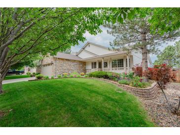 Charming home with manicured lawn and stone accents, showcasing curb appeal at 10877 W 55Th Ln, Arvada, CO 80002