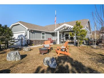 Charming home with a cozy front yard featuring an outdoor seating area and a fire pit at 819 Meadow Ln, Palmer Lake, CO 80133