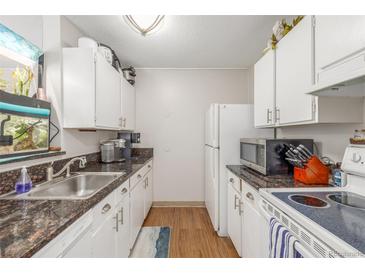 Galley kitchen features white cabinets, granite counters, and sleek stainless steel appliances at 2281 S Vaughn Way # 316A, Aurora, CO 80014