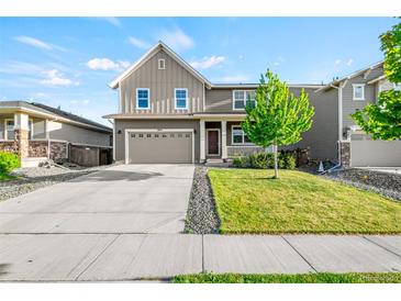 Charming two-story home with a well-manicured lawn and a two-car garage, curb appeal at 3074 Kestrel St, Brighton, CO 80601