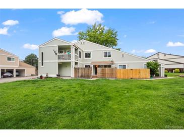 Spacious backyard showcasing a well-maintained lawn, a fenced in area, and a multi-level deck at 8738 Chase Dr # 134, Arvada, CO 80003