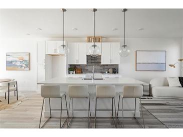 Bright, white kitchen featuring an island with bar seating and stylish pendant lighting at 8 Oneida Ct, Denver, CO 80230