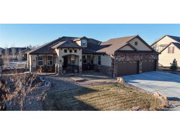 Attractive home featuring a stone-accented facade, covered porch, well-manicured landscaping, and a three-car garage at 1724 Silverado Ln, Fort Lupton, CO 80621