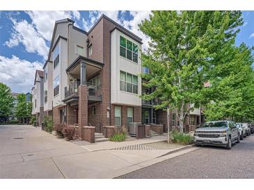 Charming townhome with brick and siding exterior, small porch, and mature landscaping at 467 S Reed Ct, Lakewood, CO 80226