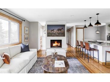 Inviting living room with hardwood floors, fireplace and bright, natural light from the large windows at 1908 Taft Dr, Lakewood, CO 80215