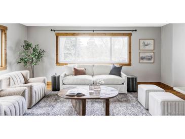 Bright living room features a large window, comfortable seating, stylish decor, and a cozy atmosphere at 1908 Taft Dr, Lakewood, CO 80215