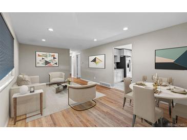 Bright living room with hardwood floors, neutral paint, and lots of natural light at 8305 Eaton Way, Arvada, CO 80003