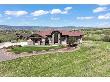 Charming home boasts a landscaped front yard, stone accents, and mountain views at 1701 Creedmoor Ct, Castle Rock, CO 80109