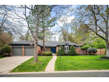 Charming brick home with mature trees, manicured lawn, and an attached two-car garage at 4011 S Ivy Ln, Cherry Hills Village, CO 80111