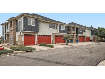 View of newly constructed townhomes featuring red garage doors and stone accents at 9300 E Florida Ave # 906, Denver, CO 80247