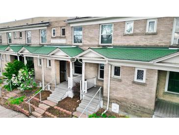 Charming townhome exterior with green roofing and well-manicured landscaping and inviting entryways at 553 N Logan St, Denver, CO 80203