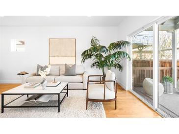 Bright living room featuring modern furniture, hardwood floors, and large windows at 418 S Gilpin St, Denver, CO 80209