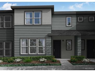 Two-story townhome with gray siding, black doors, large windows, and professionally landscaped front yard at 16787 W 94Th Way, Arvada, CO 80007