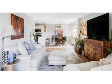 Bright living room features stylish furniture, artwork, and access to a dining area at 909 N Logan St # 3A, Denver, CO 80203