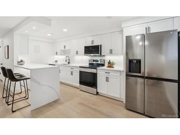 Modern kitchen featuring stainless steel appliances, bright white cabinets, and quartz countertops at 252 N Pennsylvania St # 102, Denver, CO 80203