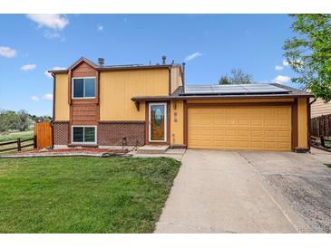Charming home featuring a two-car garage, solar panels, and a well-maintained front yard at 17703 E Nassau Pl, Aurora, CO 80013