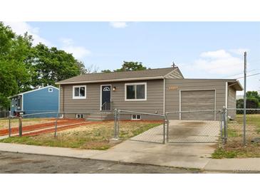 Charming single-story home features a fenced yard, attached garage, and neutral exterior paint at 7600 Kearney Dr, Commerce City, CO 80022