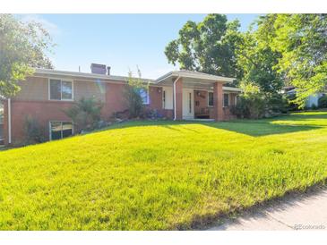 Charming single-Gathering home with lush green lawn and mature trees on a sunny day at 7930 S Kendall Ct, Littleton, CO 80128