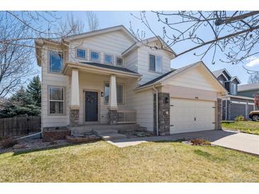 Charming two-story home with a welcoming front porch and a well-maintained lawn at 10806 Crooke Dr, Parker, CO 80134