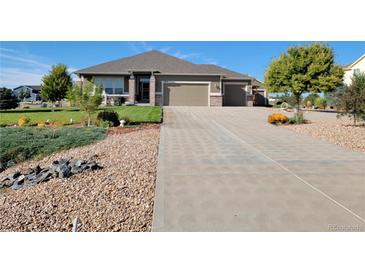 Beautiful single-story home with a well-maintained front yard, a long driveway and a two car garage at 16231 Rayburn St, Hudson, CO 80642