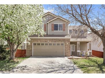 Charming two-story home with a two-car garage, blossoming tree, and a well-manicured lawn at 337 Ivory Cir, Aurora, CO 80011