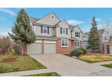 Charming two-story home features an attached two-car garage and a well-maintained front yard with mature trees at 20271 E Lake Ave, Centennial, CO 80016