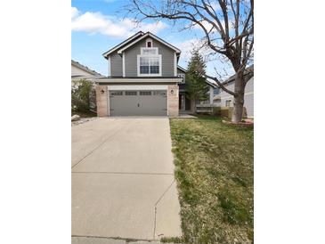 Two-story home featuring a gray exterior with a two-car garage and well-maintained front yard, offering curb appeal at 10707 Milliken St, Parker, CO 80134