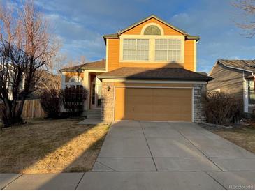 Two-story house with a tan exterior, two-car garage, and landscaping at 2786 S Cathay Way, Aurora, CO 80013