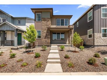Charming two-story home with a stone facade and manicured front yard at 21044 E 63Rd Dr, Aurora, CO 80019