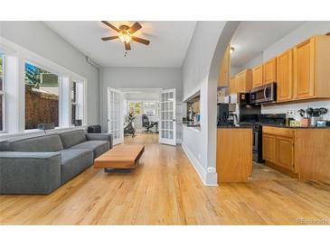Inviting living space with hardwood floors, neutral walls, and an open layout to the kitchen at 1640 N Downing St # 103, Denver, CO 80218
