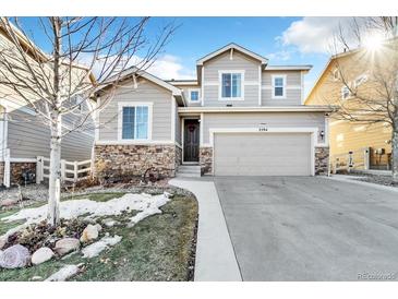 Charming home with a two-car garage, stone accents, and landscaped front yard at 2594 Scoter Ln, Castle Rock, CO 80104