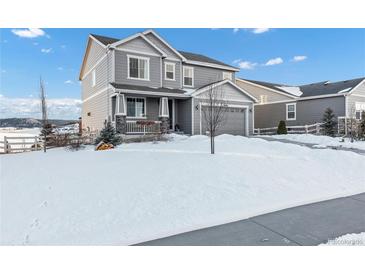 Two-story house with gray siding, snowy yard, and attached garage at 2648 Fair Meadow Pl, Castle Rock, CO 80104