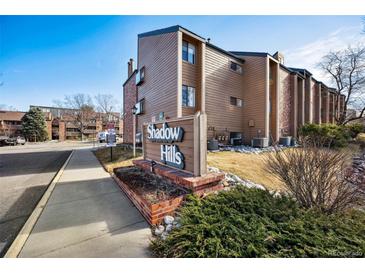 Shadow Hills condo community offers brick accents and manicured landscaping, with clear community signage at 12360 W Nevada Pl # 206, Lakewood, CO 80228