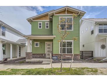 Charming two-story home with green siding, large windows, and well-manicured lawn at 910 Promenade Dr, Superior, CO 80027
