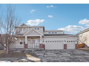 Charming two-story home with a three car garage, front porch and brick accents, located in a desirable neighborhood at 4844 Mt Evans St, Brighton, CO 80601