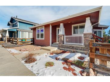 Ranch style home with red siding, stone accents, and a covered porch at 16845 Buffalo Valley Path, Monument, CO 80132