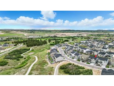 Beautiful aerial view of the community with a walking trail surrounded by greenery and mountains in the background at 624 Simmental Loop, Castle Rock, CO 80104